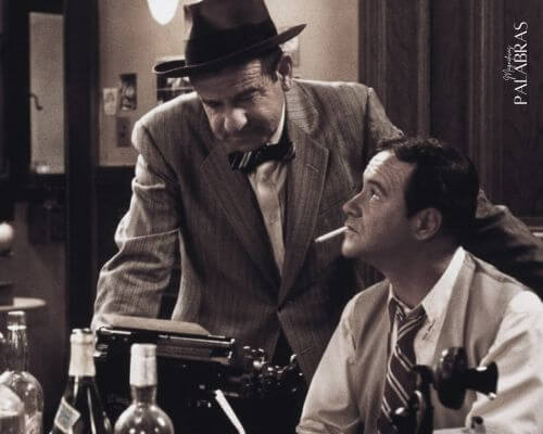 Fotograma de la película Primera Plana con Jack Lemmon y Walter Matthau en la redacción del periódico con botellas de licor sobre la mesa